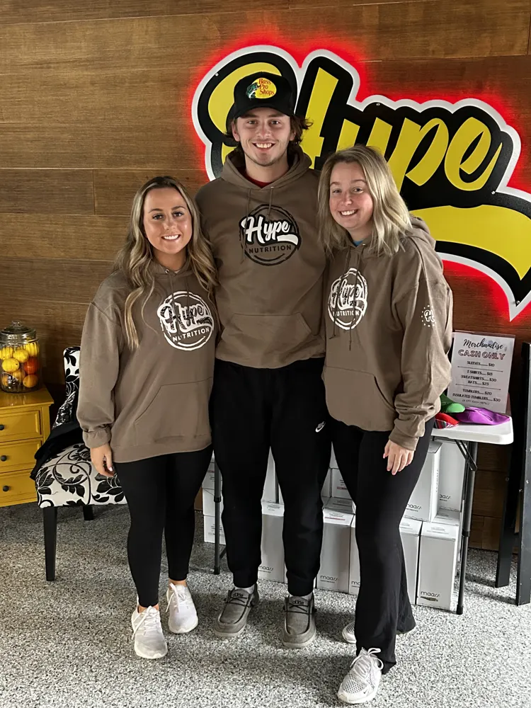 Friends in Hype hoodies at the Hype sign
