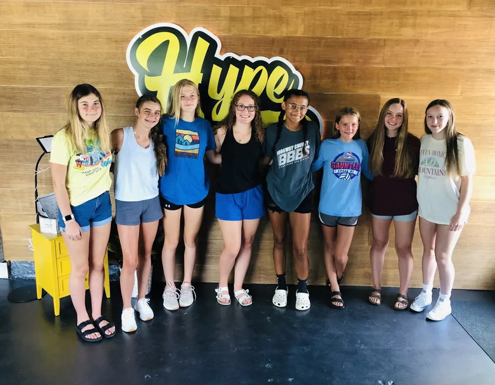 A group of girls in front of the Hype sign