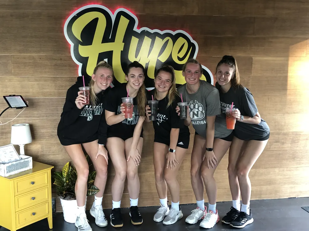 Friends with drinks at the Hype sign