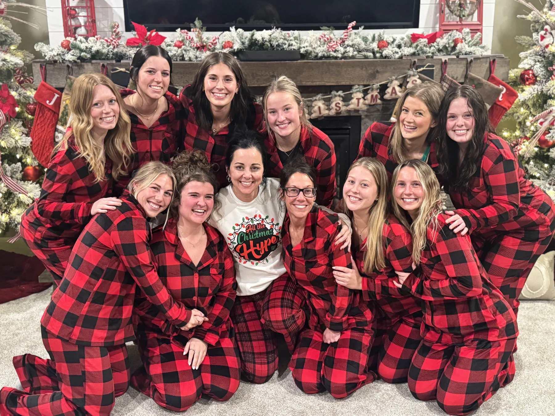Reba and the Hype crew in matching red plaid pajamas by the Christmas tree