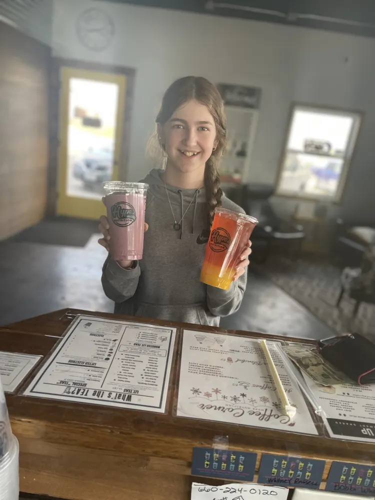A customer with two Hype drinks at the counter