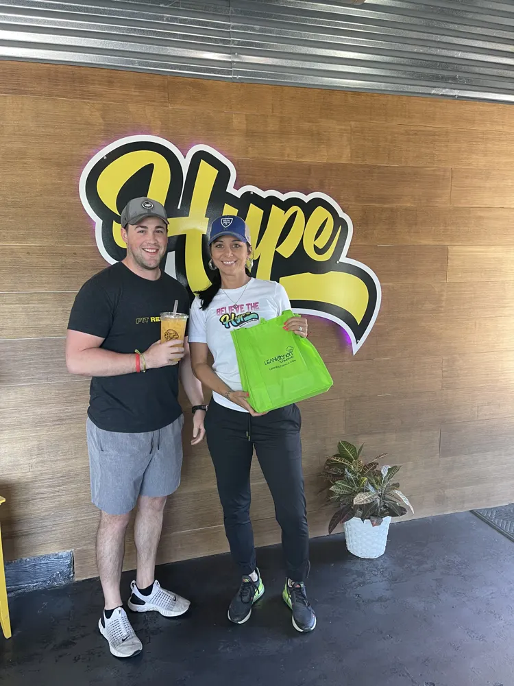 A couple with their Hype order at the sign