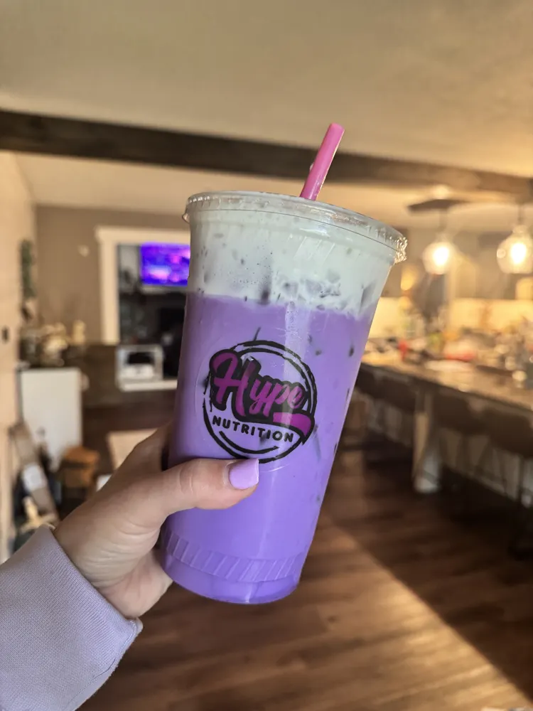 A purple Hype drink held up in the shop