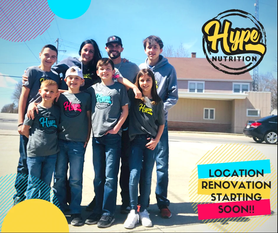 Jake, Reba and their six kids in Hype Nutrition shirts outside the first location