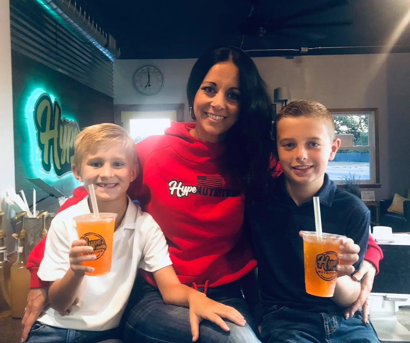 Reba with two of the kids holding Hype drinks in the shop