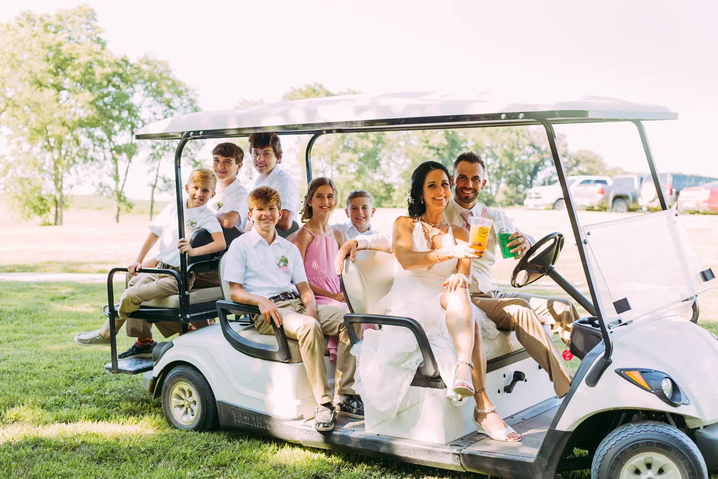 Jake, Reba and the kids on a golf cart on their wedding day, holding Hype drinks
